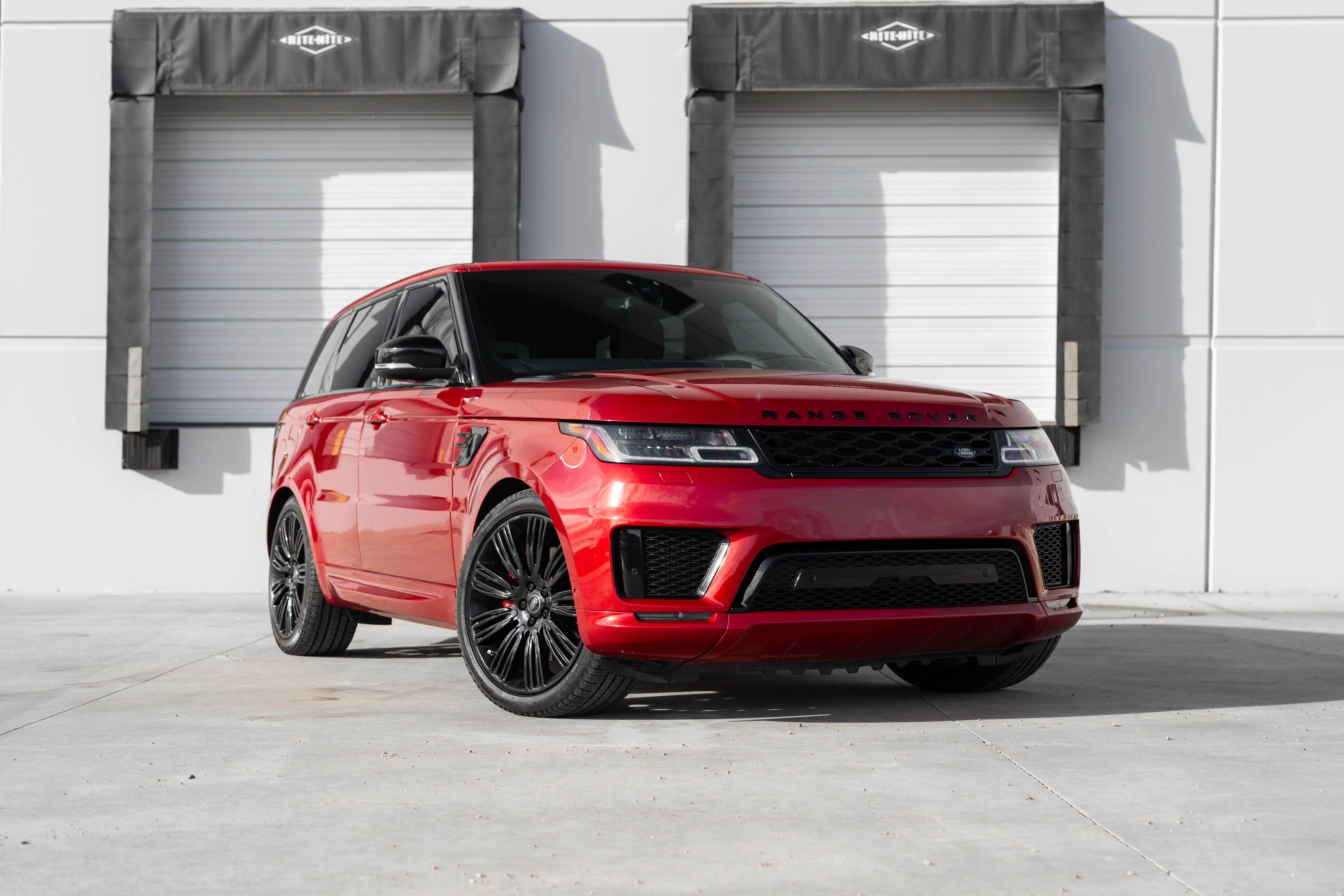 Red Land Rover Range Rover Sport with black wheels, front three-quarter view